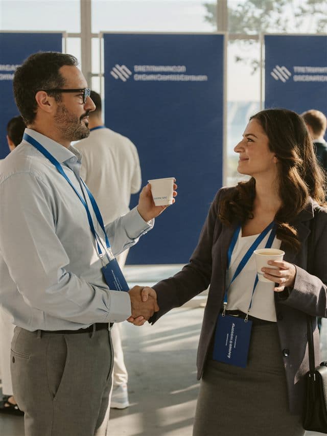 Two professionals shaking hands at a B2B event