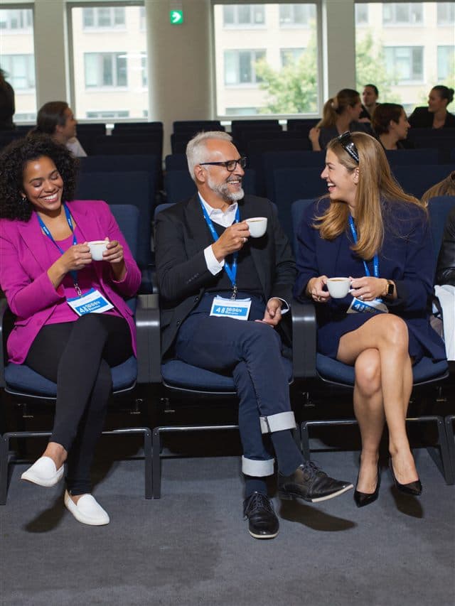 A group of professionals talking at a conference lounge